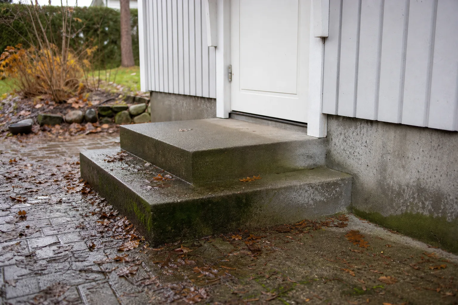 Regnvatten som blivit stående i en spricka på en betongtrappa utomhus